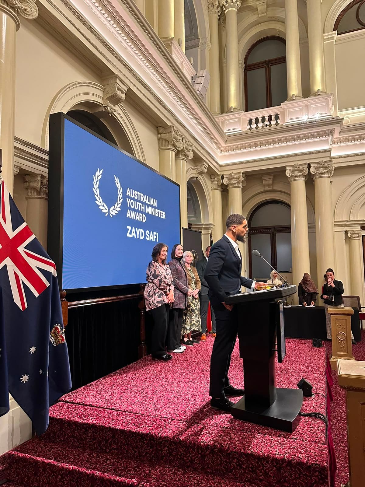 Zayd Safi speaking at a podium at the Australian Youth Minister Award ceremony